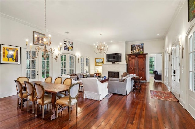 20 Beechwood Gardens Ln, Covington, LA 70435 - dining space featuring a chandelier, french doors, dark wood-style floors, a fireplace, and ornamental molding