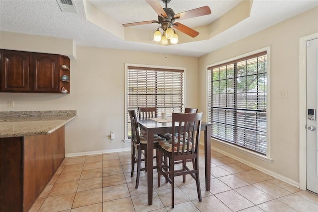 111 Thatcher Dr, Slidell, LA 70461 - dining room with a ceiling fan, light tile patterned flooring, baseboards, a tray ceiling, and a textured ceiling