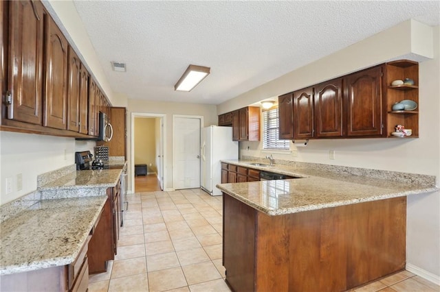 111 Thatcher Dr, Slidell, LA 70461 - kitchen with freestanding refrigerator, a sink, range with electric stovetop, a peninsula, and a textured ceiling
