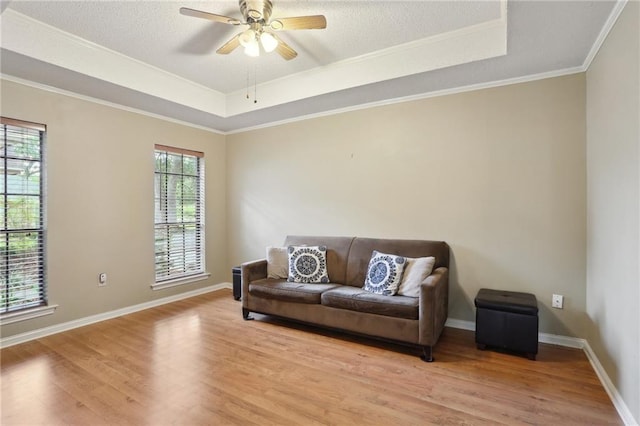 111 Thatcher Dr, Slidell, LA 70461 - living area featuring a raised ceiling, light wood-style flooring, ceiling fan, ornamental molding, and baseboards