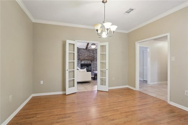 111 Thatcher Dr, Slidell, LA 70461 - spare room featuring light wood-style flooring, ornamental molding, a chandelier, french doors, and baseboards