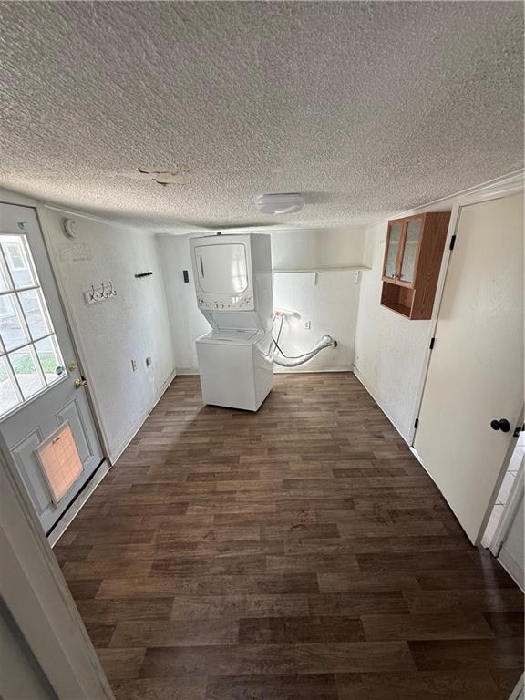 245 W Tish Dr, Avondale, LA 70094 - basement featuring stacked washing machine and dryer, a textured ceiling, and dark wood-type flooring