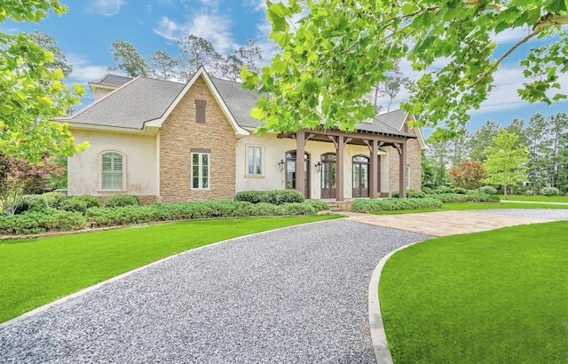 26 Hummingbird Rd, Covington, LA 70433 - view of front facade with stone siding, stucco siding, and a front lawn
