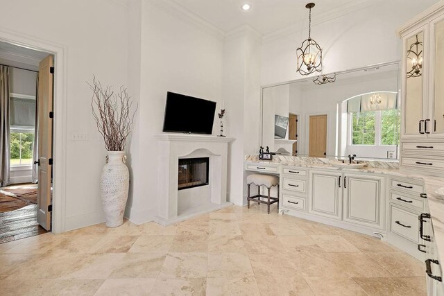 26 Hummingbird Rd, Covington, LA 70433 - bathroom with vanity, crown molding, a chandelier, a glass covered fireplace, and baseboards