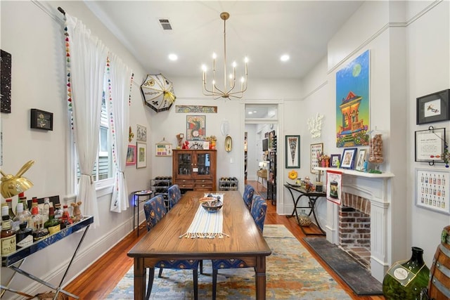 155 Alix St, New Orleans, LA 70114 - dining room featuring wood finished floors, a chandelier, baseboards, a fireplace with flush hearth, and recessed lighting
