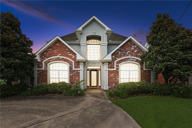 4908 Avron Blvd, Metairie, LA 70006 - view of front of house with stucco siding, brick siding, roof with shingles, and a yard