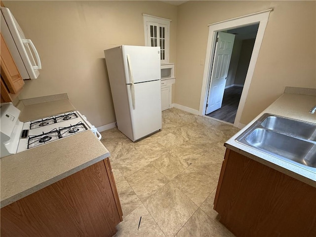 33739 Highway Dr, Jefferson, LA 70121 - kitchen featuring white appliances, a sink, baseboards, and light countertops