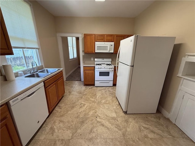 33739 Highway Dr, Jefferson, LA 70121 - kitchen with white appliances, a sink, plenty of natural light, and brown cabinetry