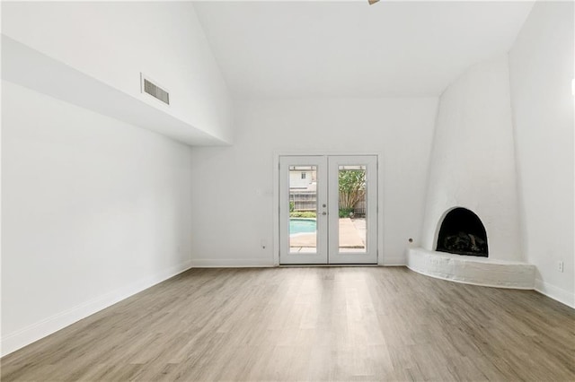 5117 Academy Dr, Metairie, LA 70003 - unfurnished living room with wood finished floors, a brick fireplace, french doors, and high vaulted ceiling