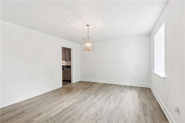 5117 Academy Dr, Metairie, LA 70003 - unfurnished room featuring a chandelier and light wood-style flooring