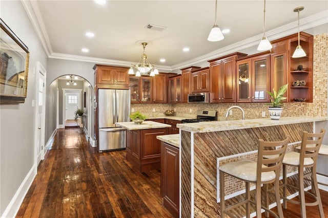 2720 New Orleans St, New Orleans, LA 70119 - kitchen featuring appliances with stainless steel finishes, a peninsula, dark wood-type flooring, crown molding, and recessed lighting