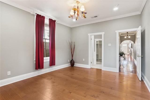 2720 New Orleans St, New Orleans, LA 70119 - unfurnished room featuring a chandelier, ornamental molding, arched walkways, wood finished floors, and baseboards