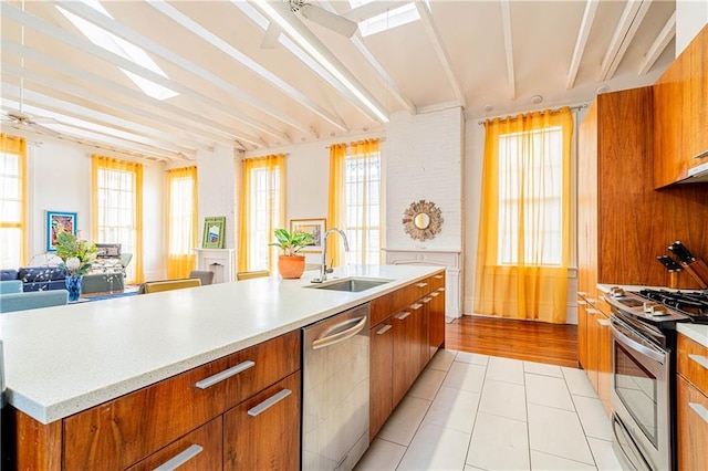 1260 Esplanade Ave Unit 2, New Orleans, LA 70119 - kitchen featuring a sink, appliances with stainless steel finishes, brown cabinetry, open floor plan, and modern cabinets