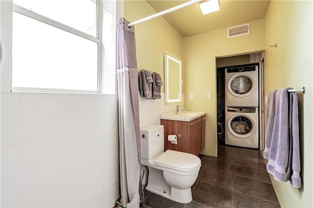 1260 Esplanade Ave Unit 2, New Orleans, LA 70119 - bathroom with stacked washer / drying machine, toilet, vanity, tile patterned flooring, and curtained shower