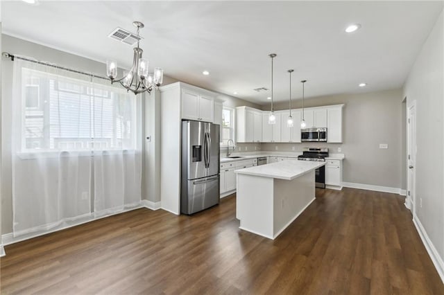 3225 Milan St, New Orleans, LA 70125 - kitchen with appliances with stainless steel finishes, white cabinets, a chandelier, dark wood-style flooring, and recessed lighting