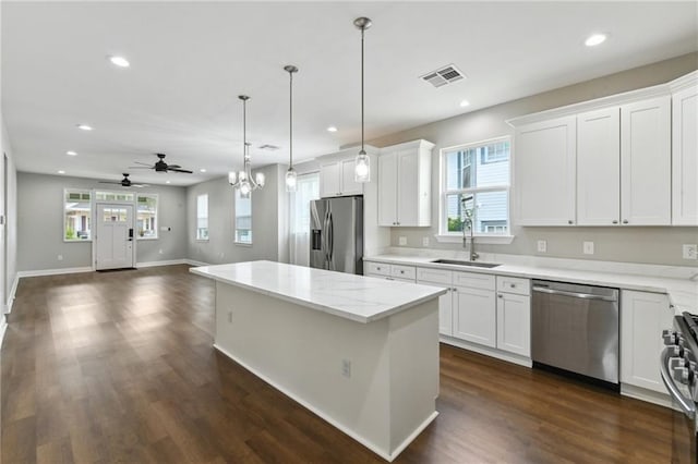 3225 Milan St, New Orleans, LA 70125 - kitchen with stainless steel appliances, a sink, recessed lighting, a kitchen island, and white cabinets