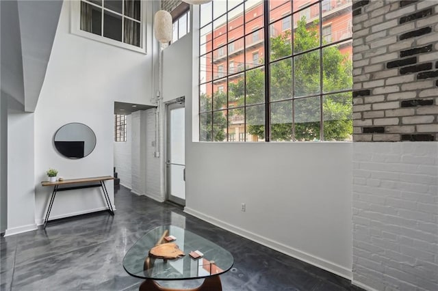 1103 Tchoupitoulas St Unit 102, New Orleans, LA 70130 - unfurnished living room with baseboards, a high ceiling, and concrete flooring