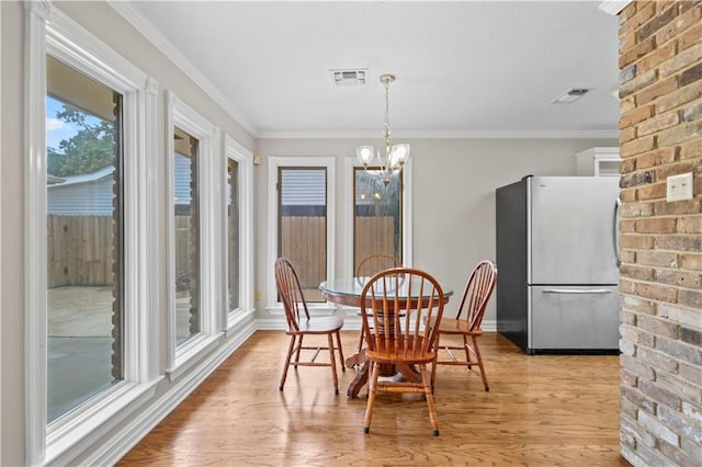 1029 Beverly Garden Dr, Metairie, LA 70002 - dining space with a chandelier, light wood-style floors, crown molding, and baseboards