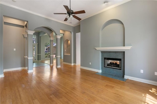 7218 Brookwood Dr, Mandeville, LA 70471 - unfurnished living room with a ceiling fan, wood finished floors, decorative columns, arched walkways, and a fireplace