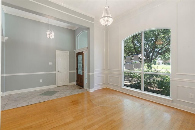 7218 Brookwood Dr, Mandeville, LA 70471 - unfurnished room with a chandelier, a decorative wall, crown molding, and wood finished floors