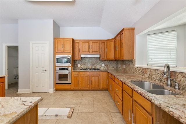 7218 Brookwood Dr, Mandeville, LA 70471 - kitchen featuring stainless steel appliances, a sink, tasteful backsplash, light stone countertops, and lofted ceiling