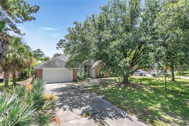 7218 Brookwood Dr, Mandeville, LA 70471 - obstructed view of property featuring concrete driveway, a garage, brick siding, and a front yard