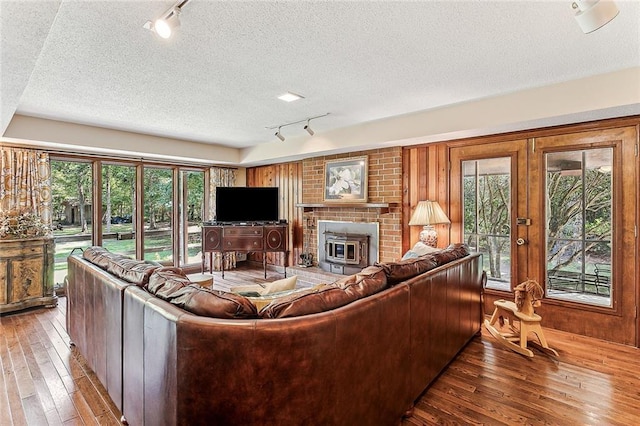 101 Lefleur Dr, Slidell, LA 70460 - living room with rail lighting, hardwood / wood-style flooring, a textured ceiling, plenty of natural light, and a fireplace