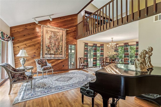 101 Lefleur Dr, Slidell, LA 70460 - sitting room with wooden walls, a chandelier, wood finished floors, a high ceiling, and rail lighting