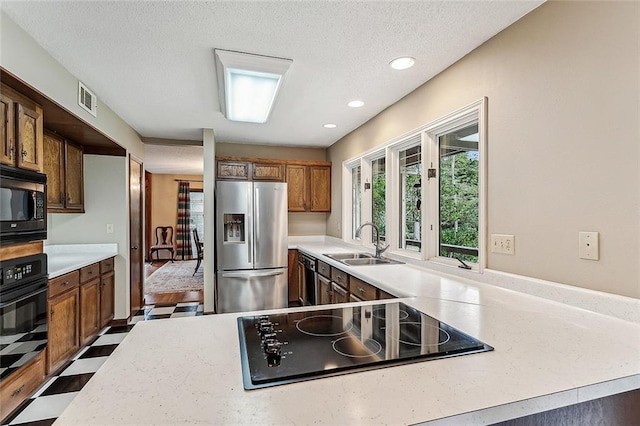 101 Lefleur Dr, Slidell, LA 70460 - kitchen featuring black appliances, light countertops, brown cabinetry, recessed lighting, and a textured ceiling