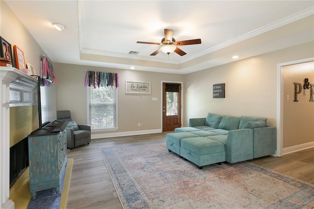 220 Canulette Rd, Slidell, LA 70458 - living room with a tray ceiling, ornamental molding, ceiling fan, wood finished floors, and baseboards
