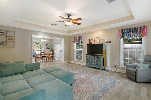 220 Canulette Rd, Slidell, LA 70458 - living area with a tray ceiling, crown molding, wood finished floors, a ceiling fan, and baseboards