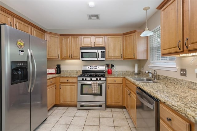 220 Canulette Rd, Slidell, LA 70458 - kitchen featuring appliances with stainless steel finishes, pendant lighting, light stone countertops, light tile patterned flooring, and a sink