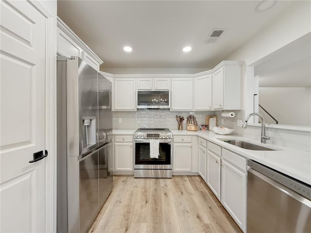 616 Marina Dr, Slidell, LA 70458 - kitchen with appliances with stainless steel finishes, a sink, white cabinetry, light countertops, and recessed lighting