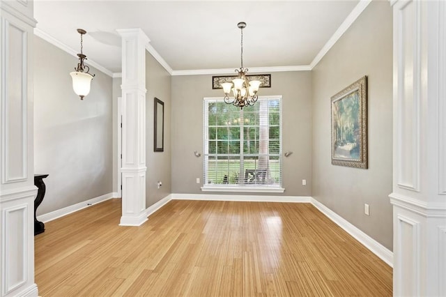 156 Egret St, Covington, LA 70433 - unfurnished dining area with light wood-style flooring, ornate columns, baseboards, a chandelier, and crown molding