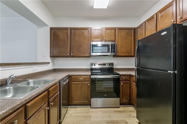 6765 Corporate Blvd Unit 11102, Baton Rouge, LA 70809 - kitchen featuring stainless steel appliances, a sink, light wood finished floors, and dark countertops