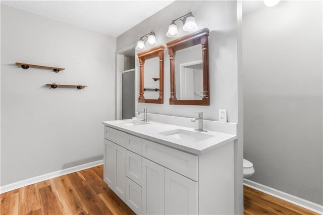 30425 Eden Church Rd, Denham Springs, LA 70726 - bathroom with toilet, double vanity, baseboards, wood finished floors, and a shower with shower door