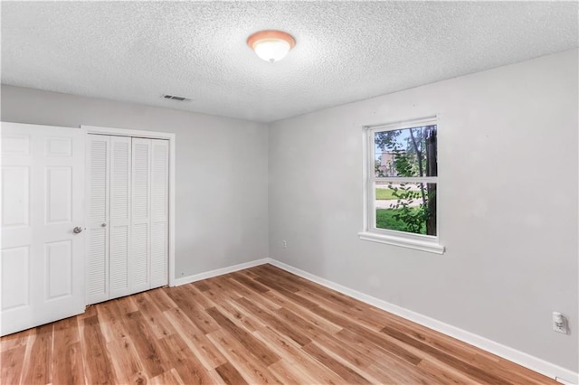 30425 Eden Church Rd, Denham Springs, LA 70726 - unfurnished bedroom with light wood finished floors, a closet, a textured ceiling, and baseboards
