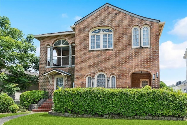 1706 Metairie Rd, Metairie, LA 70005 - view of front of house featuring brick siding, a balcony, and a front lawn