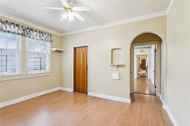 1706 Metairie Rd, Metairie, LA 70005 - spare room featuring arched walkways, light wood-type flooring, ceiling fan, ornamental molding, and baseboards