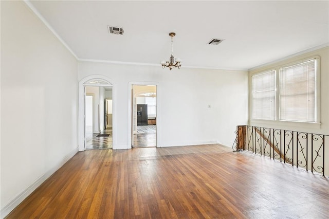 1706 Metairie Rd, Metairie, LA 70005 - empty room with crown molding, a chandelier, hardwood / wood-style flooring, baseboards, and arched walkways