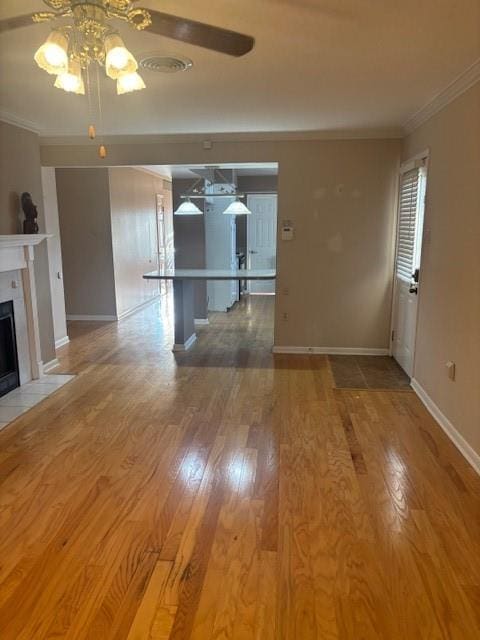 3107 Metairie Heights Ave, Metairie, LA 70002 - unfurnished living room with ceiling fan, crown molding, a fireplace with flush hearth, wood finished floors, and baseboards