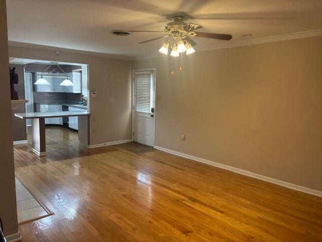 3107 Metairie Heights Ave, Metairie, LA 70002 - unfurnished living room with ceiling fan, crown molding, wood finished floors, and baseboards
