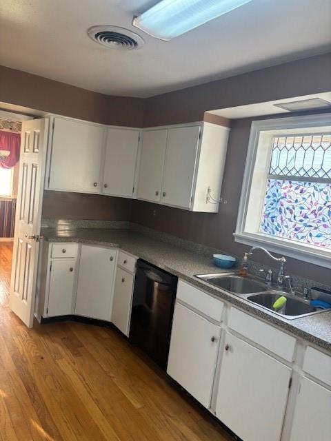 3107 Metairie Heights Ave, Metairie, LA 70002 - kitchen with dishwasher, wood finished floors, a sink, and white cabinets