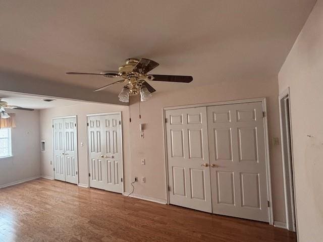 3107 Metairie Heights Ave, Metairie, LA 70002 - unfurnished bedroom with multiple closets, wood finished floors, baseboards, and a ceiling fan
