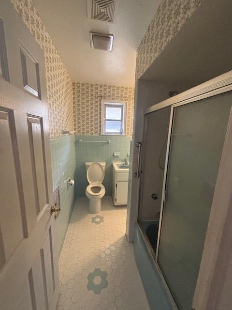 3107 Metairie Heights Ave, Metairie, LA 70002 - bathroom with wallpapered walls, toilet, vanity, shower / bath combination with glass door, and tile patterned flooring
