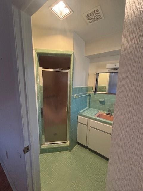 3107 Metairie Heights Ave, Metairie, LA 70002 - full bath featuring vanity, tile walls, a stall shower, and tile patterned flooring