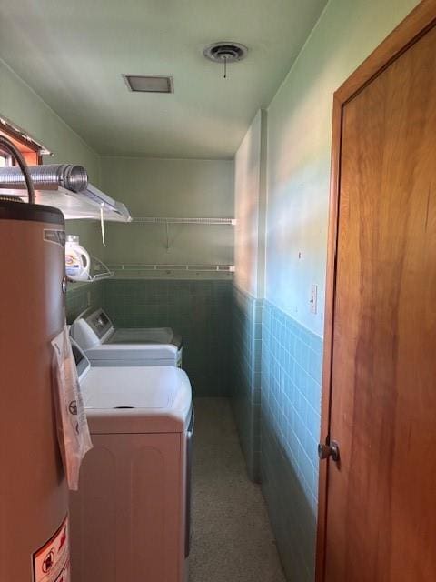 3107 Metairie Heights Ave, Metairie, LA 70002 - laundry area featuring water heater, tile walls, washer and clothes dryer, and a wainscoted wall
