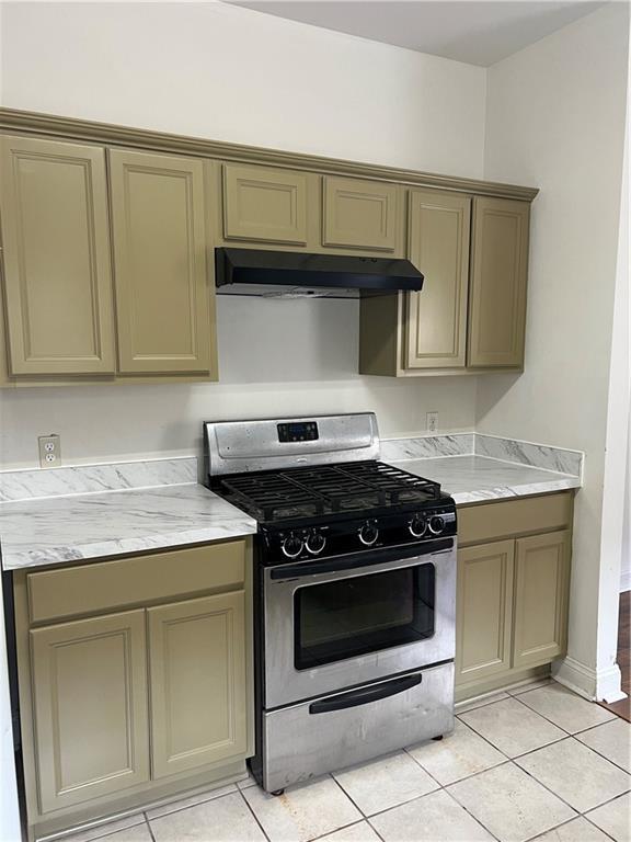 732 S Lopez St, New Orleans, LA 70119 - kitchen featuring gas range, under cabinet range hood, and light tile patterned floors