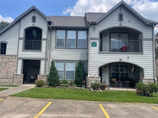 350 Emerald Forest Blvd Unit 17103, Covington, LA 70433 - view of front facade with a balcony, uncovered parking, and brick siding