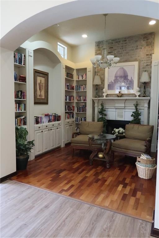 350 Emerald Forest Blvd Unit 17103, Covington, LA 70433 - sitting room with wood finished floors, built in features, arched walkways, and a chandelier